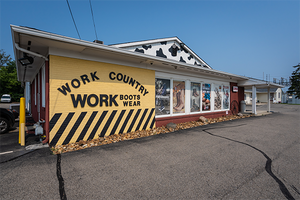 brick building with yellow and red brick with Work Country Work Boots Wear in black letters on side