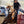 Load image into Gallery viewer, woman in western clothes and black cowgirl hat riding brown horse around a barrel in a dirt arena