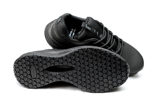 Black work safety sneakers with focus on sole design on white background