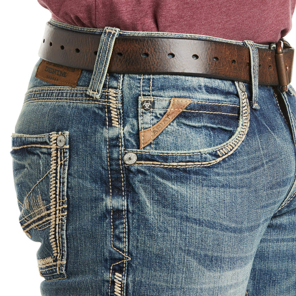 close up details of mens medium wash denim front right pocket and back pocket with ivory stitching and brown belt