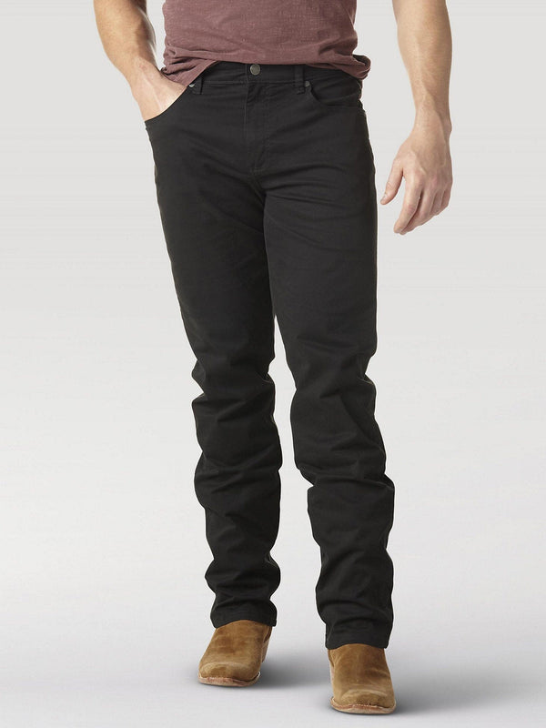 man wearing black denim jeans with brown shoes and right hand in front pocket