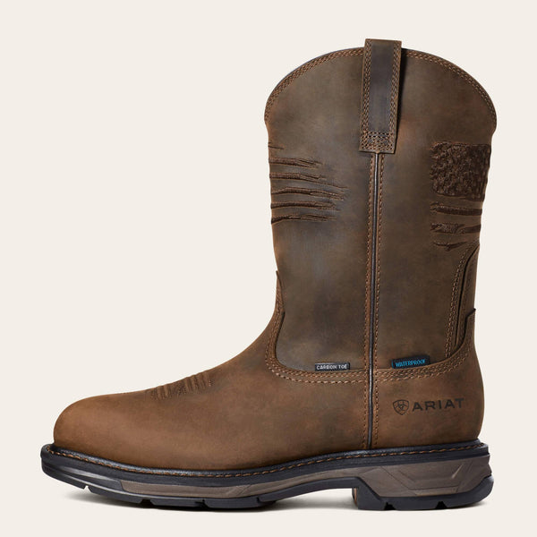 left side view of brown distressed western work boot with a rugged American flag embroidered across the shaft and Ariat logo stamped on heel