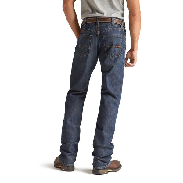 back view of man wearing grey shirt tucked into dark blue jeans wearing brown work boots
