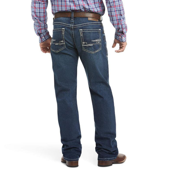 back view of man wearing blue jeans and a plaid shirt