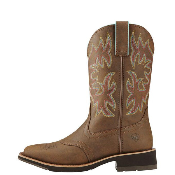 side view of light brown cowgirl boot with pink, yellow, and light blue embroidery
