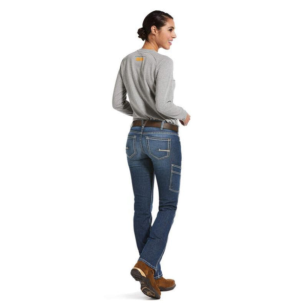 back full body view of Woman wearing light grey shirt tucked into light blue jeans