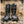 Load image into Gallery viewer, two black high top boots on top of rocks
