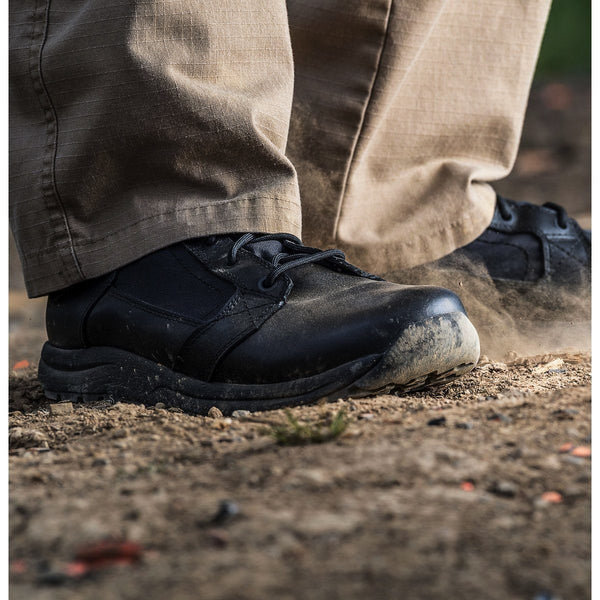 action shot of black boots on feet in dirt