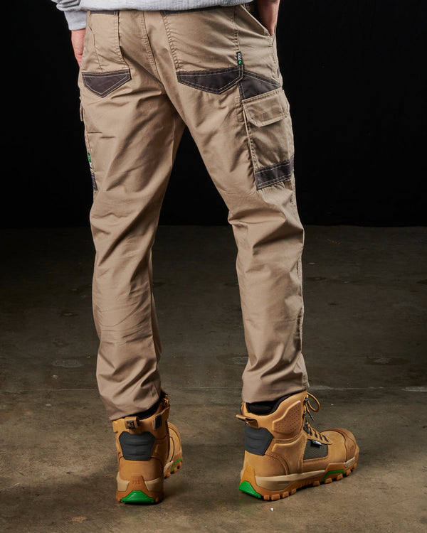 rear view of man wearing khaki light weight work pants with black details on back and cargo pockets,, light grey sweatshirt, and tan boots
