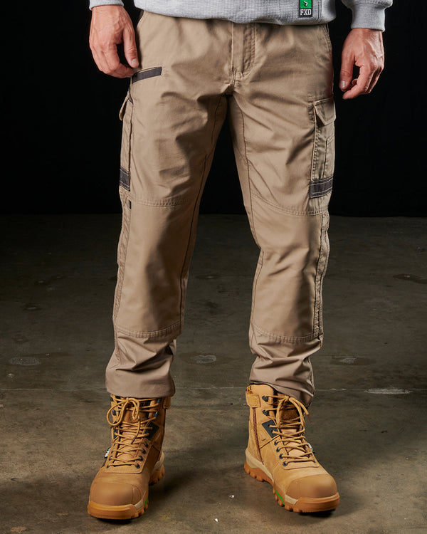 man wearing khaki light weight work pants, light grey sweatshirt, and tan boots