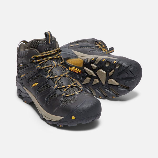 two black boots with black and khaki sole and green and khaki laces