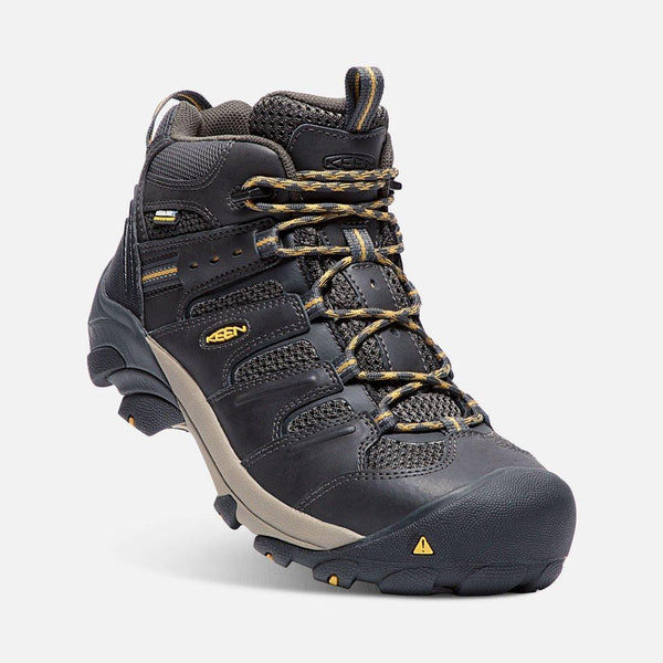 angled  view of black boot with black and khaki sole and green and khaki laces