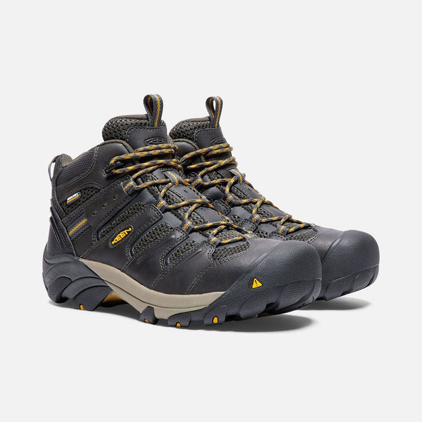 two black boots with black and khaki sole and green and khaki laces
