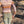 Load image into Gallery viewer, back of woman with thumbs in back pockets, wearing cream and brown patterned long sleeve button up shirt, light grey pants, and black cowgirl hat