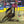 Load image into Gallery viewer, woman in western clothes and brown cowgirl hat riding brown horse around a barrel in a dirt arena