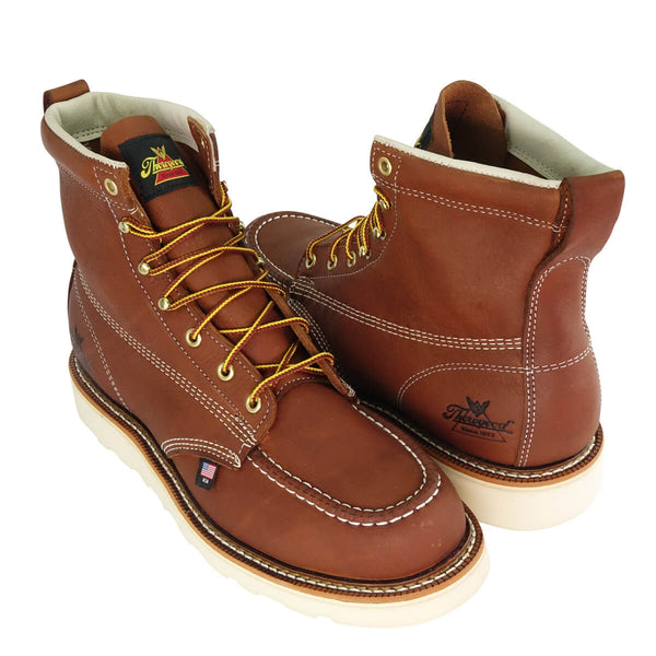two brown/red mid-rise boots with yellow and brown laces and white soles