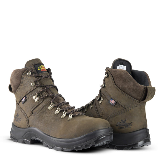 two dark brown boots with black sole and gold eyelets