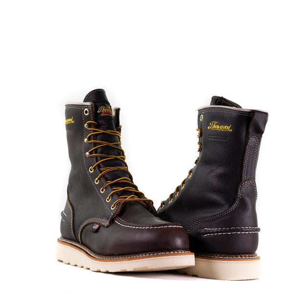 alternating pair of dark brown high top moccasin style boots with yellow and brown laces and white wedge soles