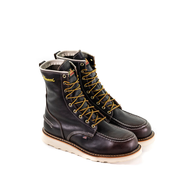 pair of dark brown high top moccasin style boots with yellow and brown laces and white wedge soles