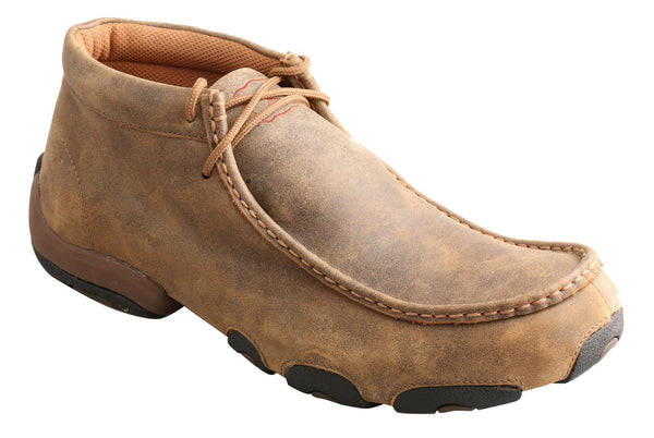 mens light brown shoe with circular black soles and orange x logo
