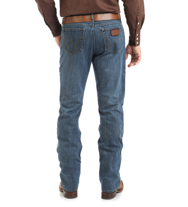 Man in Dark Brown Solid button up and brown belt in rough blue jeans back view