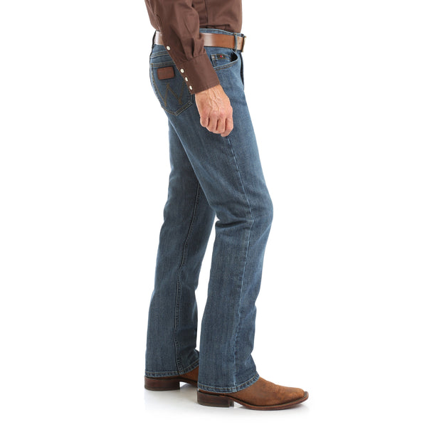 Man in Dark Brown Solid button up and brown belt in rough blue jeans side view