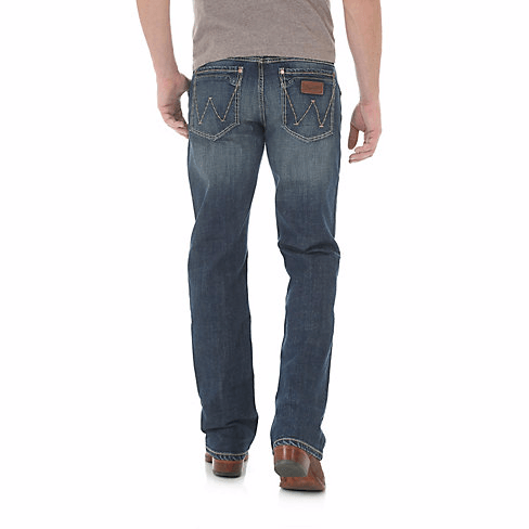 Man in sandy tshirt wearing bootcut jeans back angle