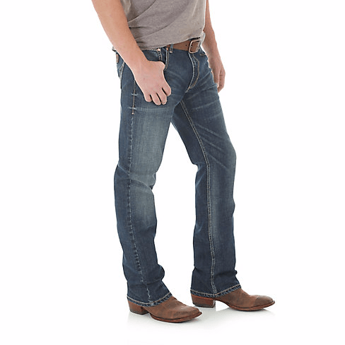 Man in sandy tshirt wearing bootcut jeans side angle
