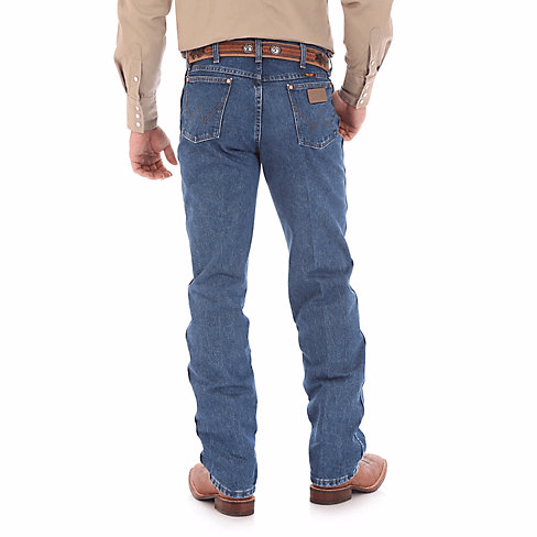 Man in Tan Button up Wearing large belt and Mute blue jeans back angle