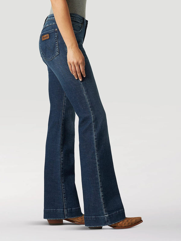 side view of women wearing wide leg blue jeans with tan boots and hand at her side