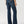 Load image into Gallery viewer, back view of women wearing wide leg blue jeans with tan boots and hands at her side