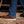 Load image into Gallery viewer, Person waring brown Ariat work boots with blue jeans on a wooden dirty floor.
