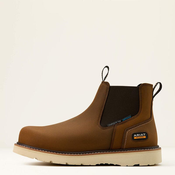 Left side view of brown chelsea boot with visible Ariat logo on a beige background