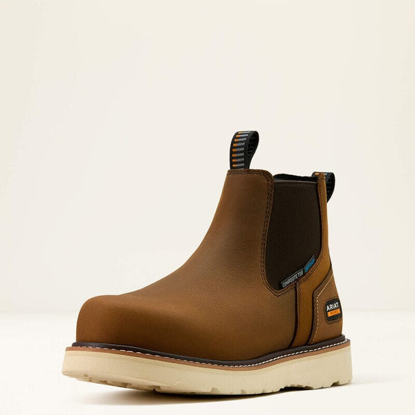 Left side front angled view of brown leather chelsea work boot with a white sole on a beige background