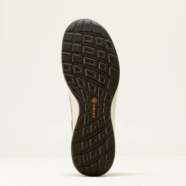 Close-up of a black shoe sole with a brand logo on a light beige background