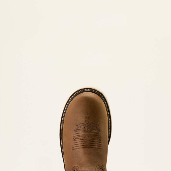 Close up detail view of a brown leather boot rounded toe on a beige background