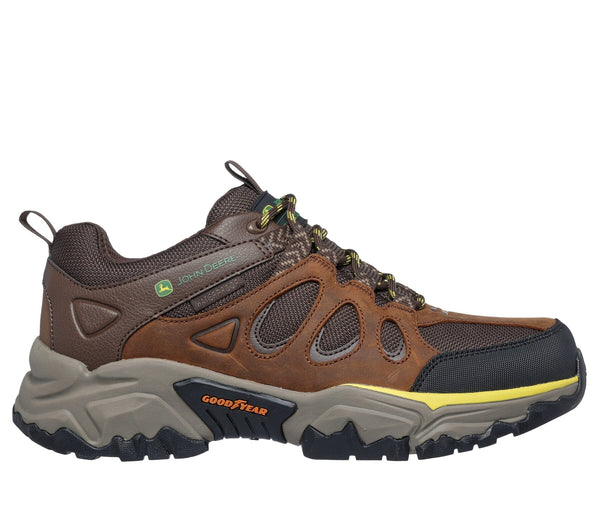 Right side view of a brown low-top lace-up outdoor work boot with leather and mesh upper, synthetic overlays, and yellow and green accent colors.