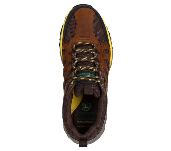 Top view of a brown low-top lace-up outdoor work boot with leather and mesh upper, synthetic overlays, and yellow and green accent colors.