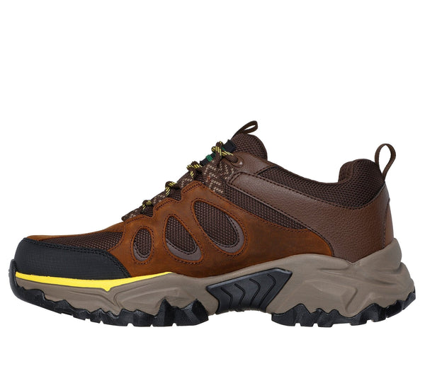 Left side view of a brown low-top lace-up outdoor work boot with leather and mesh upper, synthetic overlays, and yellow and green accent colors.