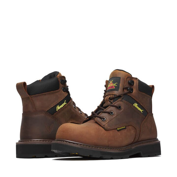 Pair of brown lace up work boots with black and yellow accents on a white background