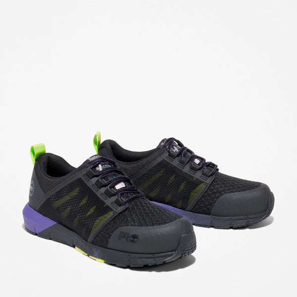 A pair of women's Timberland PRO work sneakers with composite toe, featuring a black and purple color scheme with green accents.