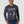 Load image into Gallery viewer, man wearing dark grey long sleeve shirt with image and hands in front pockets of jeans
