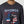 Load image into Gallery viewer, close up of man wearing dark grey long sleeve shirt with image of George Strait silhouette strumming his guitar over a red, white, and blue American flag outline of Texas
