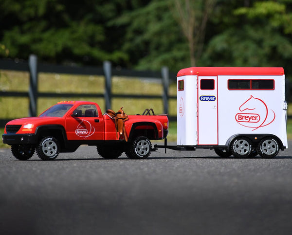 outdoor image of breyer kids toy red truck attached to white horse trailer with red roof