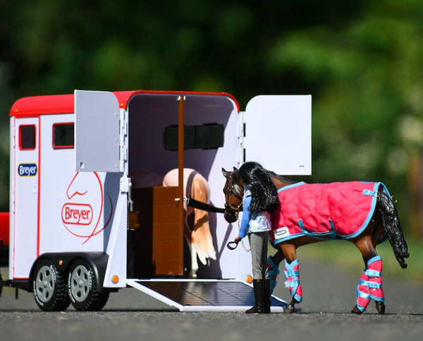 outdoor image of breyer kids toy white horse trailer with red roof and open doors and two toy horses