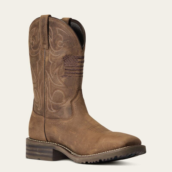 front right angle view of mens brown western boot with light stitching and american flag embroidered on front of shaft