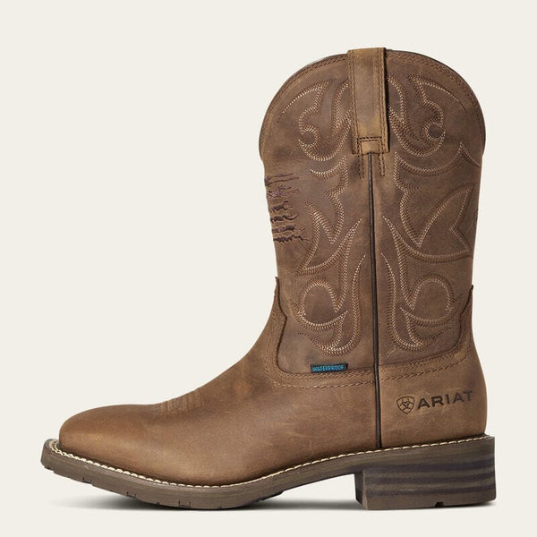 left side view of mens brown western boot with light stitching on shaft and Ariat logo stamped on side of heel