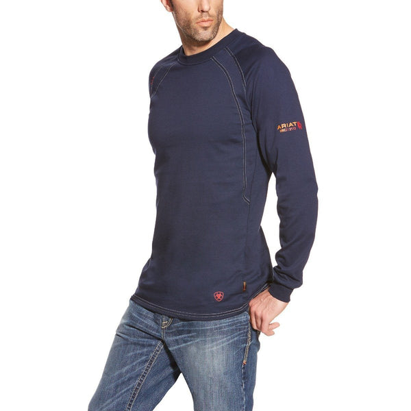 man wearing blue long sleeve shirt with Ariat logo on sleeve and blue jeans