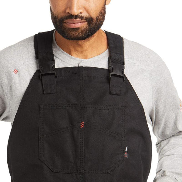 chest view of African American man wearing black bib overalls and a grey shirt