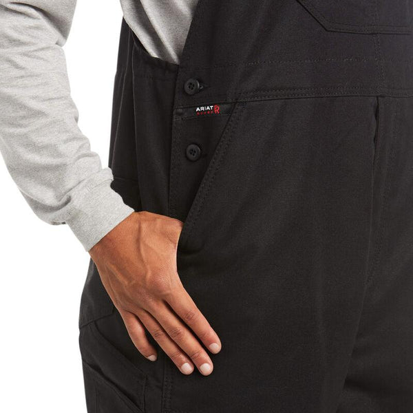 waist pocket view of African American man wearing black bib overalls and a grey shirt